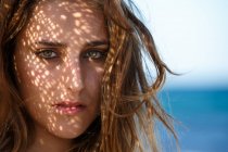Headshot einer sinnlich attraktiven Frau, die am sonnigen Strand leidenschaftlich in die Kamera blickt — Stockfoto