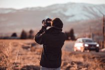 Visão traseira do macho tirando foto da bela paisagem entre colinas em dia ensolarado em Cerdanya, França — Fotografia de Stock