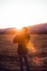 Back view of male taking photo of beautiful landscape between hills in sunny day in Cerdanya, France — Stock Photo