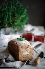 Delicioso pão de centeio aromático fresco em guardanapo perto de faca e latas com tomate compota caseira no fundo borrado — Fotografia de Stock