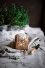 Delizioso pane di segale aromatico fresco sul tovagliolo vicino al coltello su sfondo sfocato — Foto stock