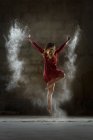 Jovem dançando e usando pó na escuridão — Fotografia de Stock