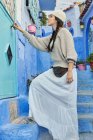 Schöne Frau spaziert zwischen blauen Häusern in Marrakesch — Stockfoto