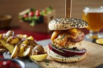 Вкусный гамбургер для гурманов с пирожками, луком и сыром, подаваемый с картофельными клинками — стоковое фото