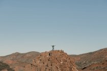 Неузнаваемый турист, стоящий на вершине холма вдали в безоблачный день — стоковое фото
