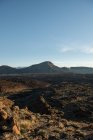 Vue pittoresque sur les terres désertiques sèches et les collines de loin par une journée sans nuages — Photo de stock