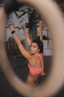 Giovane donna sportiva magra in abbigliamento sportivo facendo esercizi di pull up su barra orizzontale in palestra — Foto stock