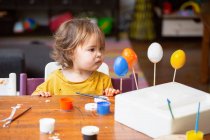 Menina da criança pintando ovo na mesa — Fotografia de Stock