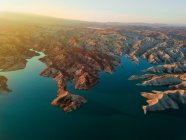 Aerial view to coast and small sandy hills at calm water in sunlight — Stock Photo