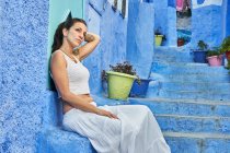 Bela mulher andando entre casas azuis em Marraquexe — Fotografia de Stock