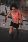 Жінка в спортивному одязі виконує вправи з резистентною смугою в спортзалі — стокове фото