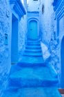 Splendida vista di strada per porta tra blu antichi edifici in pietra a Marrakech, Marocco — Foto stock