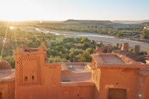 Dall'alto centro storico con costruzioni in pietra vicino a stretto fiume tra deserto e bel cielo con nuvole a Marrakech, Marocco — Foto stock