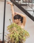 Young charming naked lady behind plant — Stock Photo