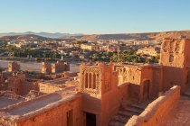 Сверху старый город с каменными сооружениями вблизи узкой реки между пустыней и красивым небом с облаками в Марракеше, Марокко — стоковое фото