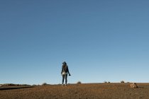 Visão traseira do fotógrafo feminino em pé com câmera e olhando para colinas no deserto — Fotografia de Stock