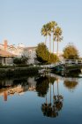Blick auf traditionelle Häuser und Brücke am ruhigen Teich bei wolkenlosem Tag — Stockfoto