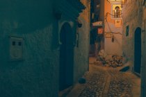 Vue imprenable sur la rue pauvre entre les anciennes maisons en soirée à Marrakech, Maroc — Photo de stock