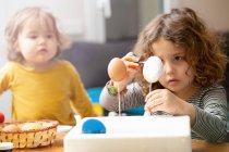 Sisters painting Easter eggs at home — Stock Photo