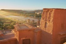 De la vieille ville avec des constructions en pierre près de la rivière étroite entre désert et beau ciel avec des nuages à Marrakech, Maroc — Photo de stock