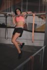 Жінка з спортивного одягу робить вправи на горизонтальному брусі в спортзалі — стокове фото