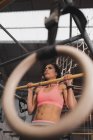 Donna in abbigliamento sportivo facendo esercizi di pull up sulla barra orizzontale in palestra — Foto stock