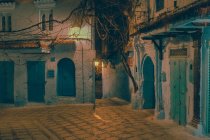 Increíble vista de la calle pobre entre casas antiguas en la noche en Marrakech, Marruecos - foto de stock