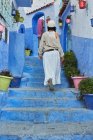 Schöne Frau spaziert zwischen blauen Häusern in Marrakesch — Stockfoto