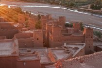 Desde el casco antiguo con construcciones de piedra cerca del estrecho río entre el desierto y la luz del sol en Marrakech, Marruecos - foto de stock