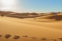 Desierto con colinas de arena y cielo azul con sol en Marrakech, Marruecos - foto de stock