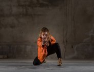 Mujer joven bailando en habitación gris - foto de stock