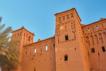 From below facade of rock construction in old city and blue sky in Marrakesh, Morocco — Stock Photo