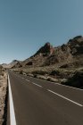 Перспективный вид на асфальтированную дорогу на суше, ведущую в горы — стоковое фото