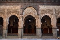 Фасад старого каменного здания со старинными дверями в Марракеше, Марокко — стоковое фото