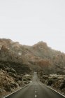 Perspektivischer Blick auf Asphaltstraße im Trockenen, die in die Berge führt — Stockfoto
