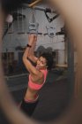 Mulher em sportswear fazendo puxar para cima exercícios na barra horizontal no ginásio — Fotografia de Stock