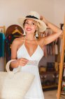 Stylische junge Frau mit Hut und Handtasche in Boutique — Stockfoto