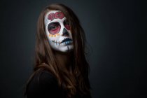 Jeune femme avec peinture effrayante visage — Photo de stock