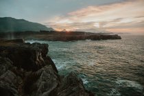 Picturesque view of high shore near stormy sea and beautiful cloudy sky at sunset in Bufones de Pria, Asturias, Spain — Foto stock