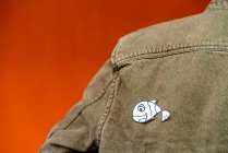 Visão traseira do cara com silhueta de papel para o dia de tolos de abril na jaqueta de jeans no fundo laranja — Fotografia de Stock