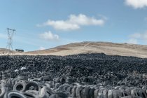 Énorme pile de vieux pneus auto entre prairie — Photo de stock