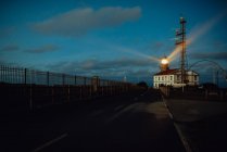 Road and lighthouse in evening — Stock Photo
