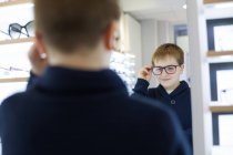 Süßer kleiner Junge probiert Brille im Brillengeschäft an — Stockfoto