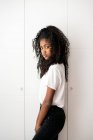 Retrato de una joven adolescente negra mirando a la cámara en un fondo blanco - foto de stock