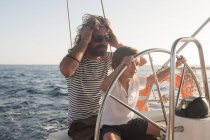 Отец и сын плывут на дорогой лодке по морю и голубому небу в солнечный день — стоковое фото