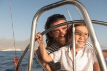 Pai feliz com crianças flutuando em barco caro no mar e céu azul em dia ensolarado — Fotografia de Stock