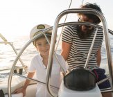 Buon padre con bambini che galleggiano su costose barche in mare e cielo blu nella giornata di sole — Foto stock