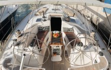 Зверху дорогий човен з фруктами на столі, що плаває на морі в сонячний день — стокове фото