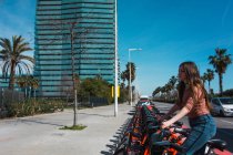 Menina tomando bicicleta de aluguel na cidade — Fotografia de Stock