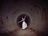 Young ballerina spinning in pipe — Stock Photo